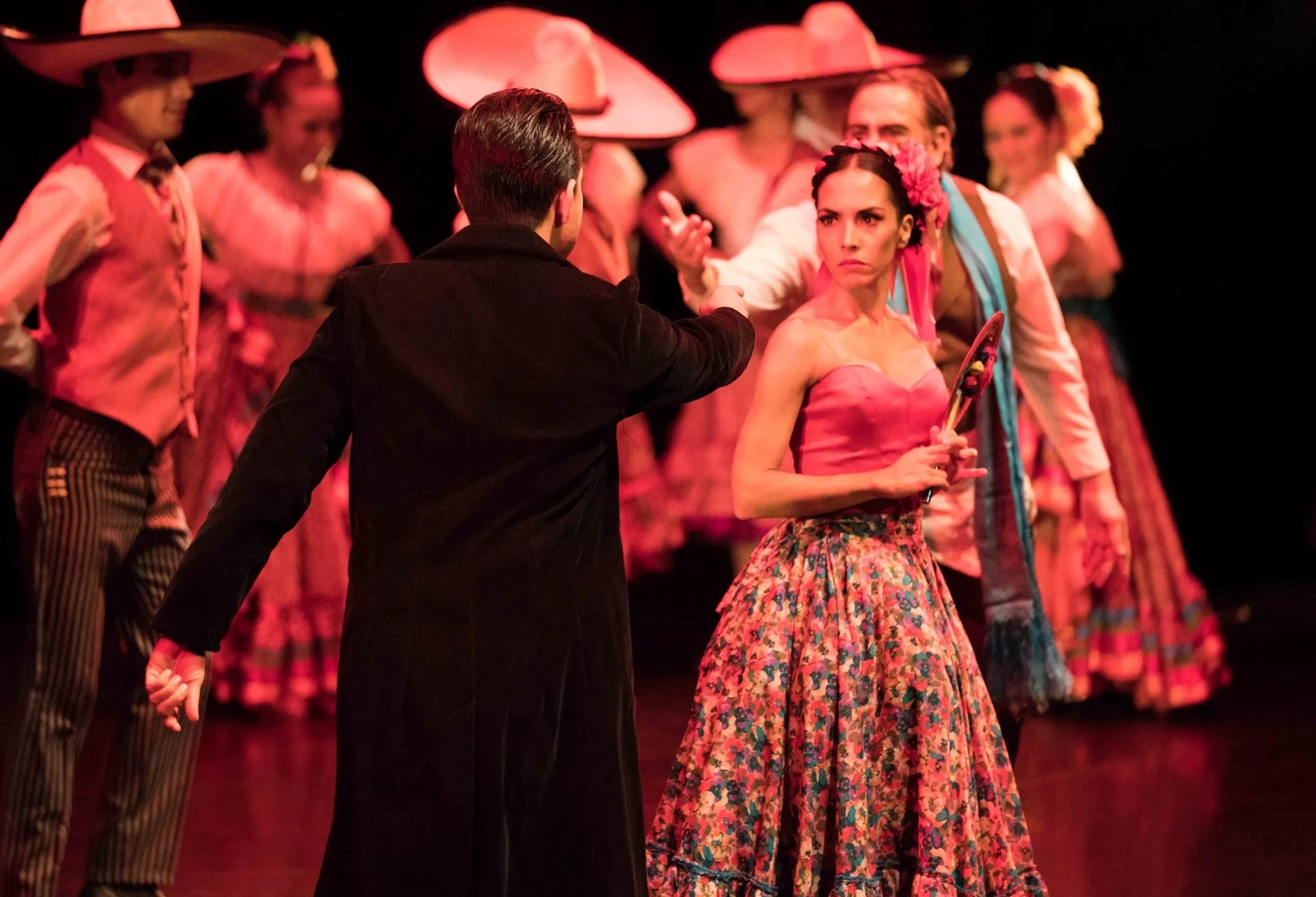 Man on stage pointing at a woman in a dress
