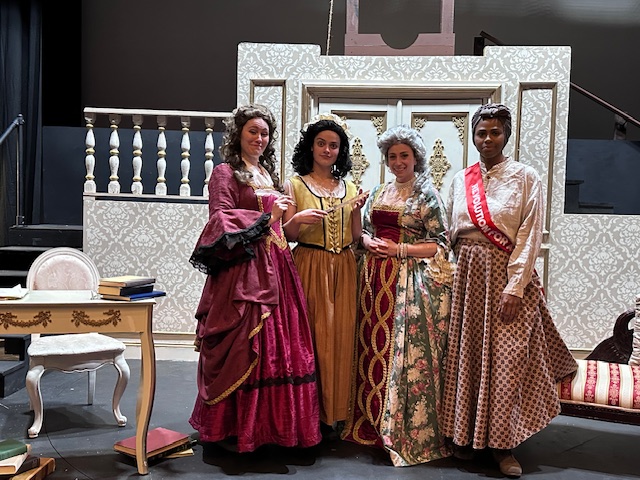 Cast of the Revolutionists posing together in dress rehearsal