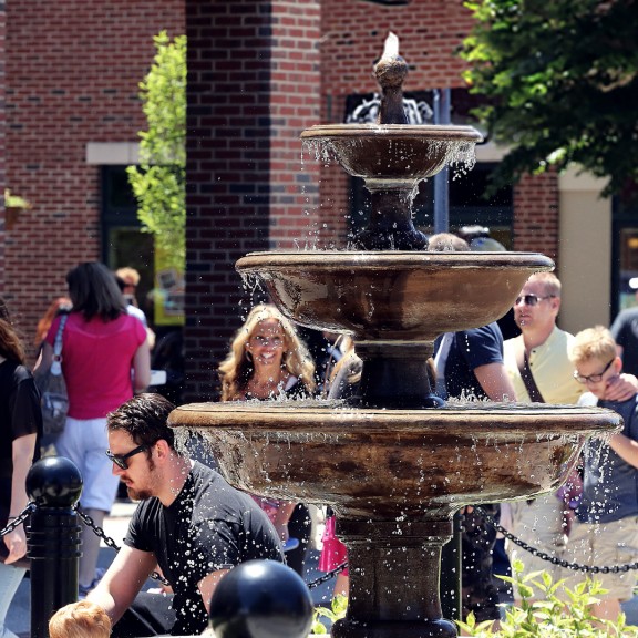 People gathered around a plaza with a fountain in the middle in Collongswood