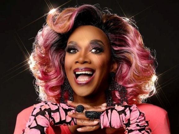 Headshot of Harmonica Sunbeam, a drag queen, wearing all pink