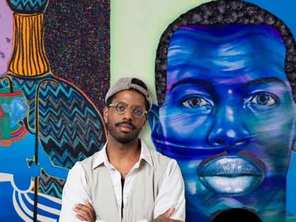 Devan Shimoyama standing in front of artwork from SHIFT exhibit