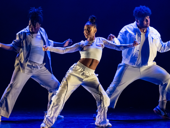 Three dancers from Camille A. Brown and Dancers performing on stage