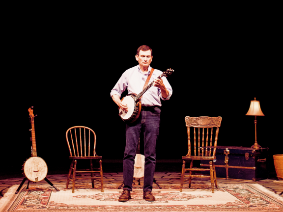 Man on stage playing a banjo