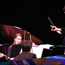 A conductor leading the Garden State Philharmonic through a performance