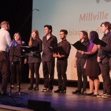 The Millville High choir performs in all black onstage