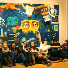 A group of students in front of a mural