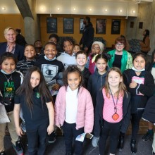 a group of kids smiles for a group photo after a music workshop