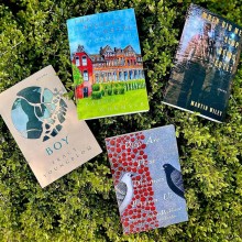 Photo of four books placed on top of a bush
