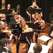A group of musicians playing instruments in a gymnasium
