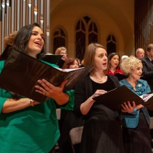 Women singing in front of a church organ