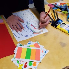 a child using blick colored pencils draws an abstract shape and colors it in