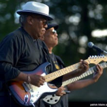 pair of musicians playing guitar outside