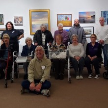 Members of the Guild of Creative Art smiling for a group photo in an art gallery