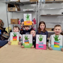 A group of children holding up the art they made in an art class at Hunterdon Art Museum