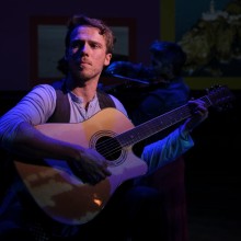 The lead of the musical Once holding his guitar at a production at Kelsey Theatre