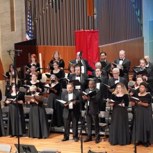 A group of people in black choir clothes singing
