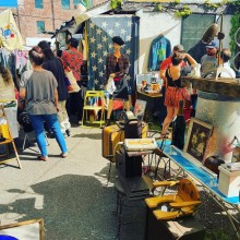 Tables and displays set up outside to sell art and vintage/used goods