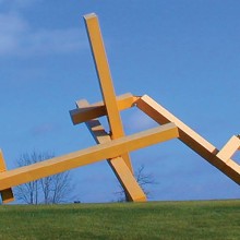 John Henry sculpture Illinois Landscape #5 out in a large grassy field with a clear blue sky