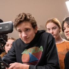 A group of kids working with a film camera
