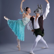 A ballet duo from A Midsummer Night’s Dream poses with their arms up facing each other