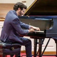 a man in a suit playing the piano