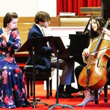 a trio of  musicians performing wearing formal attire