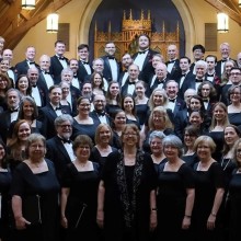 a group photo of the Harmonium Choral Society with their conductor