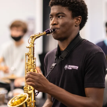 a man blowing into a saxophone