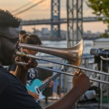 A man playing the trombone at an outdoor music event