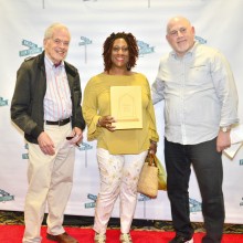 Three people posing for a picture on the Nassau Film Festival Red Carpet
