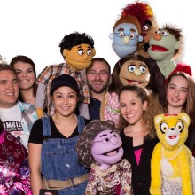 A group of actors from the musical Avenue Q take a cast photo with their puppets