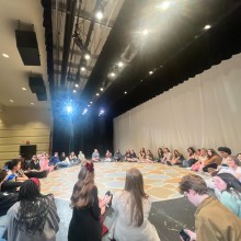 A group of kids sitting in a circle talking about team building and advocacy