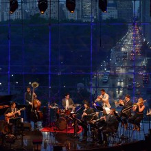 musicians performing songs in a windowed building on Central Park