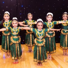 Children posing in green and gold traditional Indian dance costumes