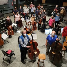 a photo taken from above of a group of masked musicians holding their instruments