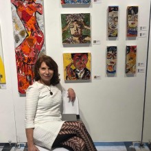 A woman sitting on a chair in front of paintings