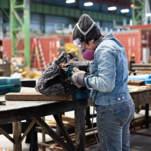 A woman welding a piece of metal art
