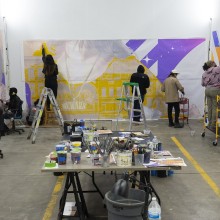 A group of people working on a mural in a room