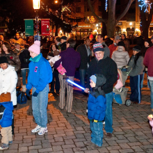 A crowd of people standing in a street at night