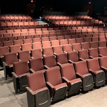 A large empty theater full of red seats
