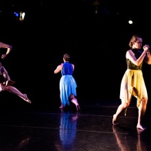 dancers in costumes onstage moving in four different directions away from each other