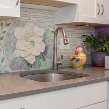 A kitchen with a sink and a flower on the wall