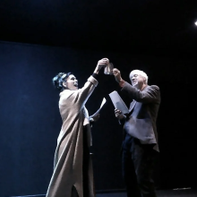 pair rehearsing a scene where they cheers two drinks