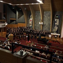 A choir performs in a large church to a modest audience