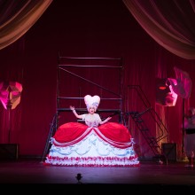 Woman onstage at NBPAC in "Candide," in a hoop skirt and a tall Marie Antoinette wig