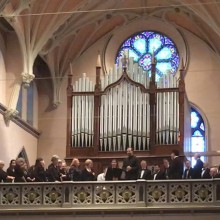 Choir singing from the balcony of a church.
