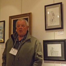A man standing in front of a wall with pictures