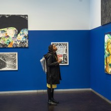Girl in art gallery looking at one of several paintings