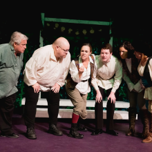 A group of people standing on a stage in costumes