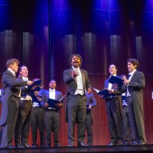 Group  of 12 male members of Chanticleer singing on Pfleeger stage in Formal concert attire with coat tails